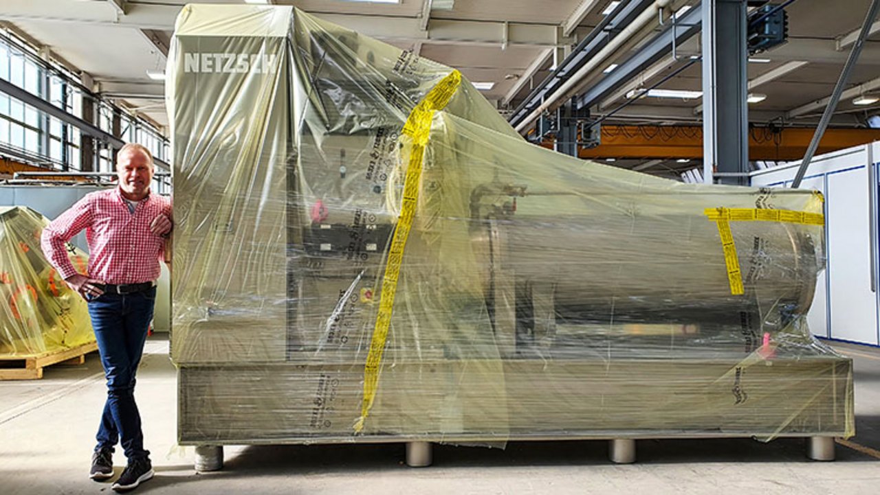 Una macchina avvolta nella pellicola ICB. Accanto ad essa si trova Hans-Jürgen Glettner, Operations Manager della Netzsch-Feinmahltechnik GmbH di Selb